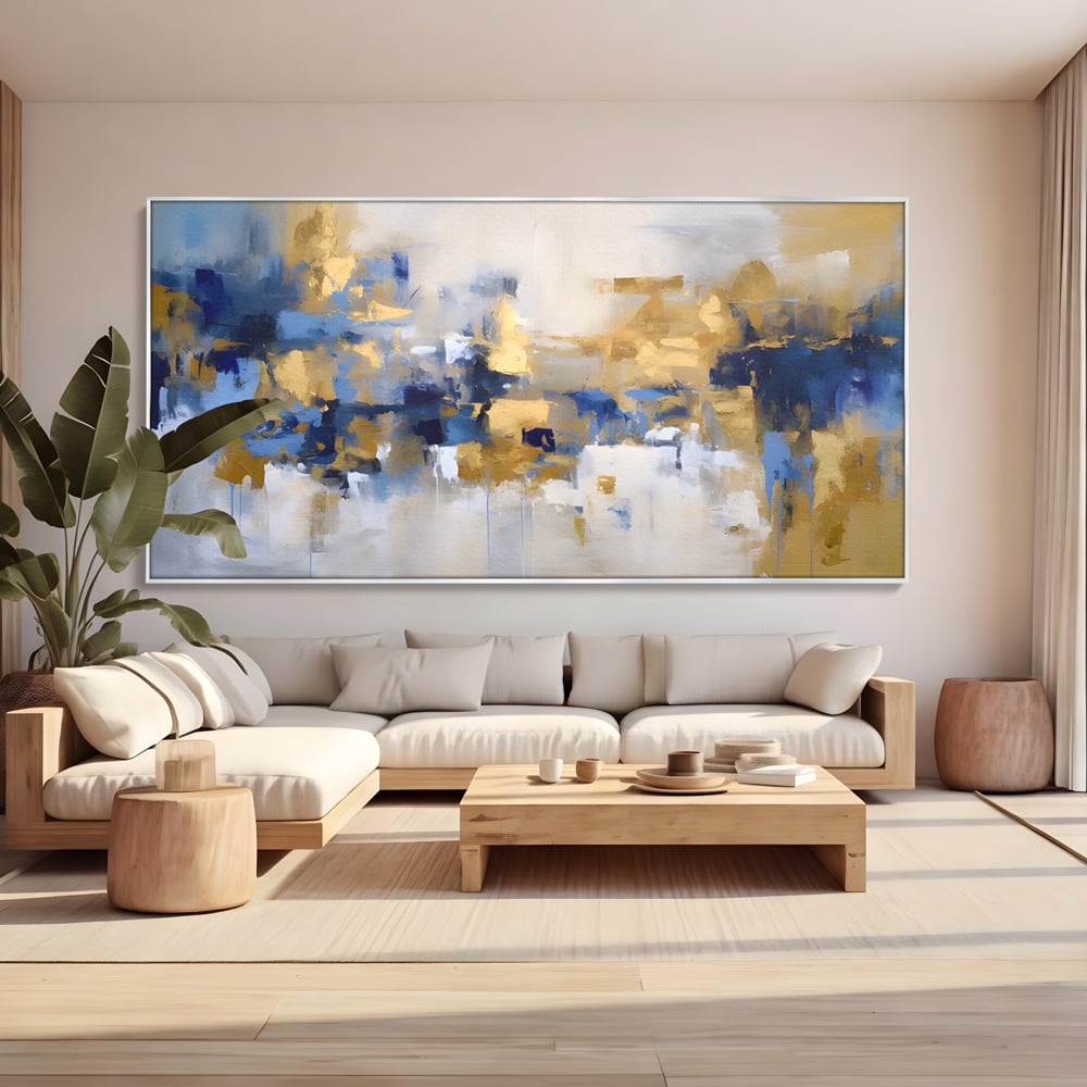 Tablou canvas cu tablou abstract cu pete aurii si albastre, in rama de aluminiu argintiu, pe perete intr-un living